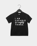 Child wearing an I am Capable of Mighty Things graphic tee in white