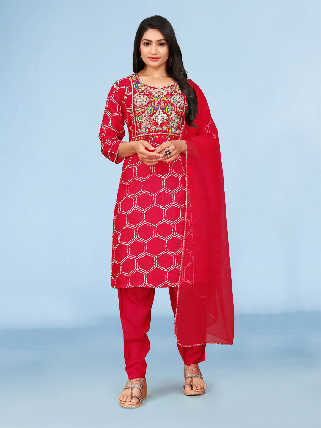 Model wearing a vibrant red printed Dola silk 3-piece kurta set with detailed handwork embroidery.