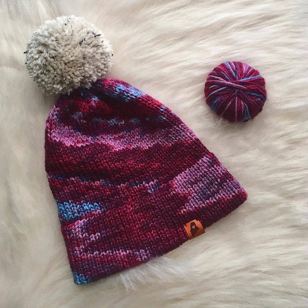 Classic double brim knit hat kit in burgundy, blue, and white wool yarn with a pom pom.