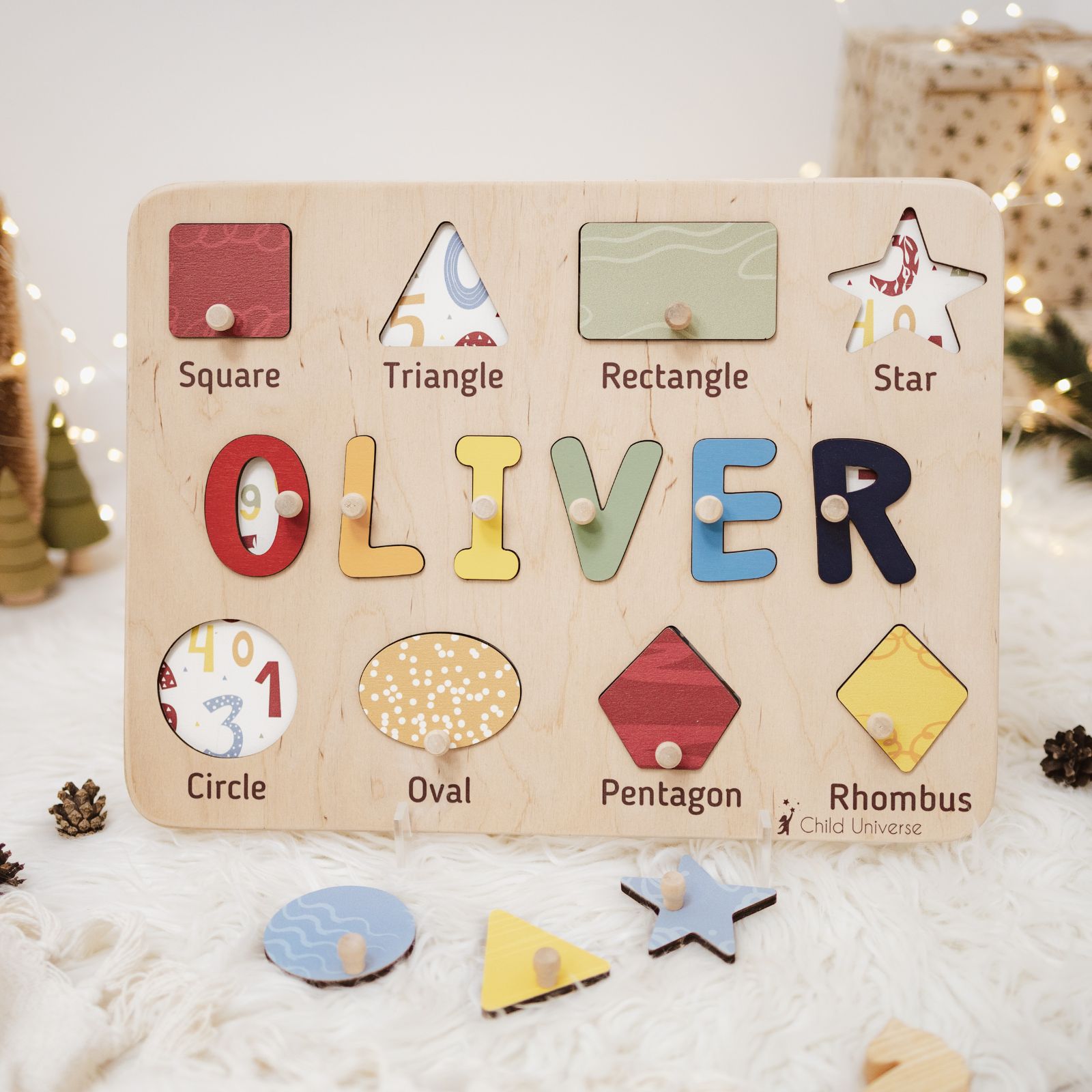 A wooden educational name puzzle board featuring colorful geometric shapes and letters, resting on a minimalist nursery shelf.
