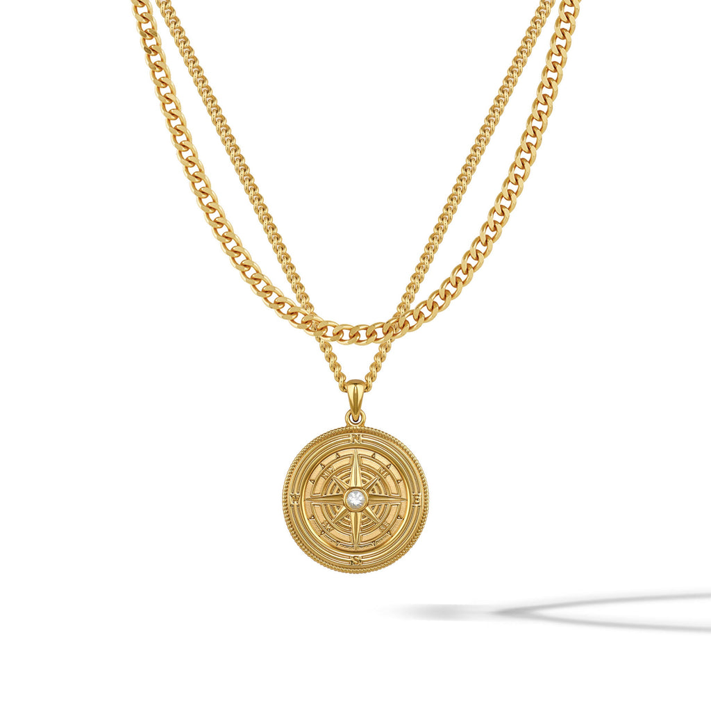 Gold-toned compass pendant featuring a central sapphire stone on a classic curb chain.