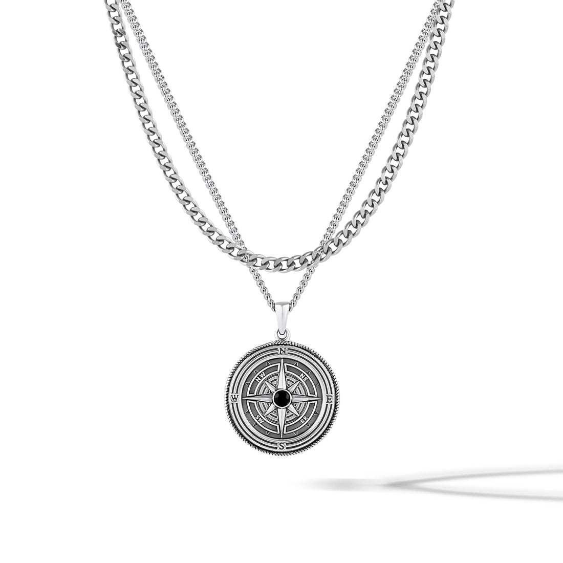 Sterling silver compass pendant featuring a central onyx stone on a classic curb chain.