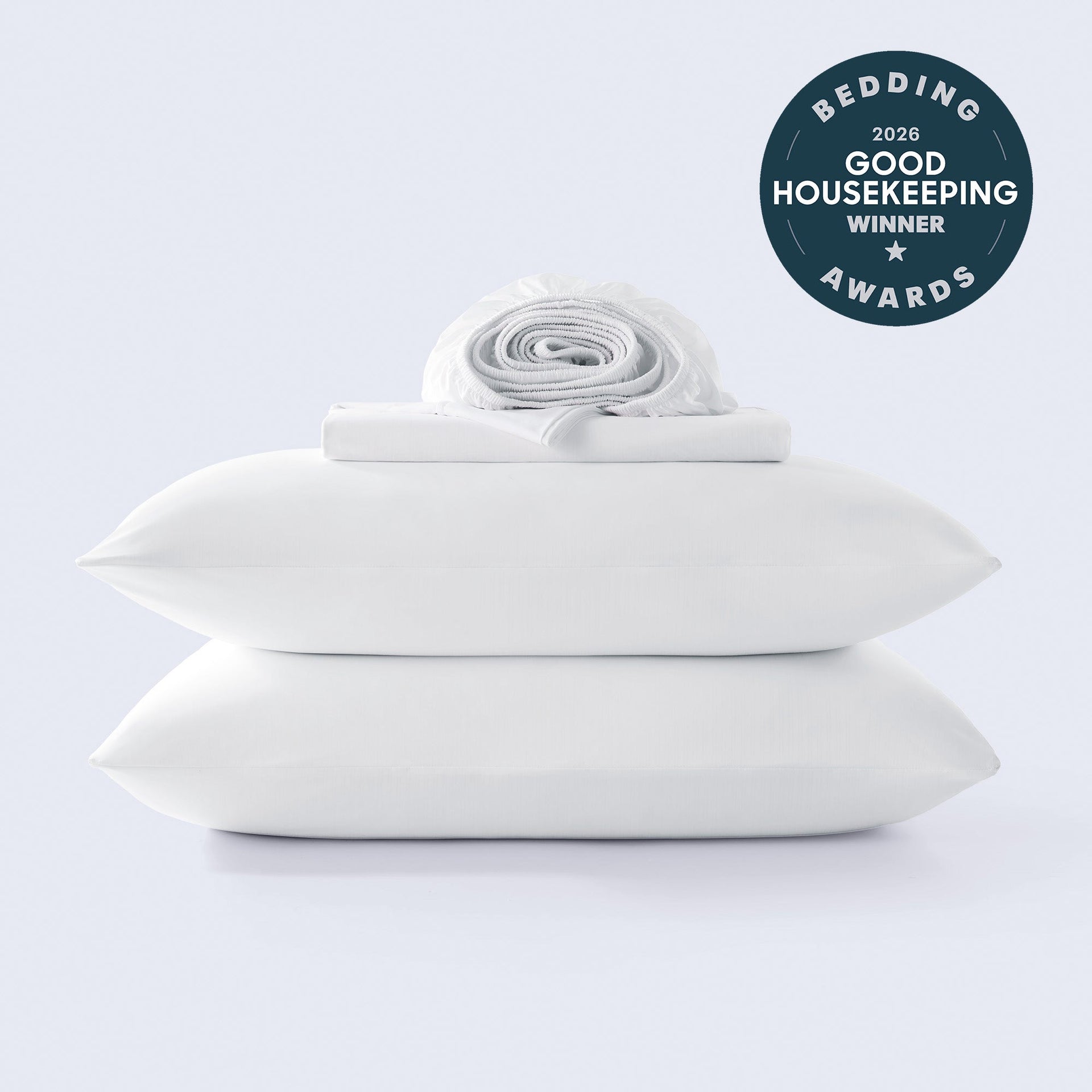 A stack of white cooling sheets with a Good Housekeeping 2026 award winner seal in the corner