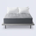 Grey cooling mattress topper on a bed with white pillows