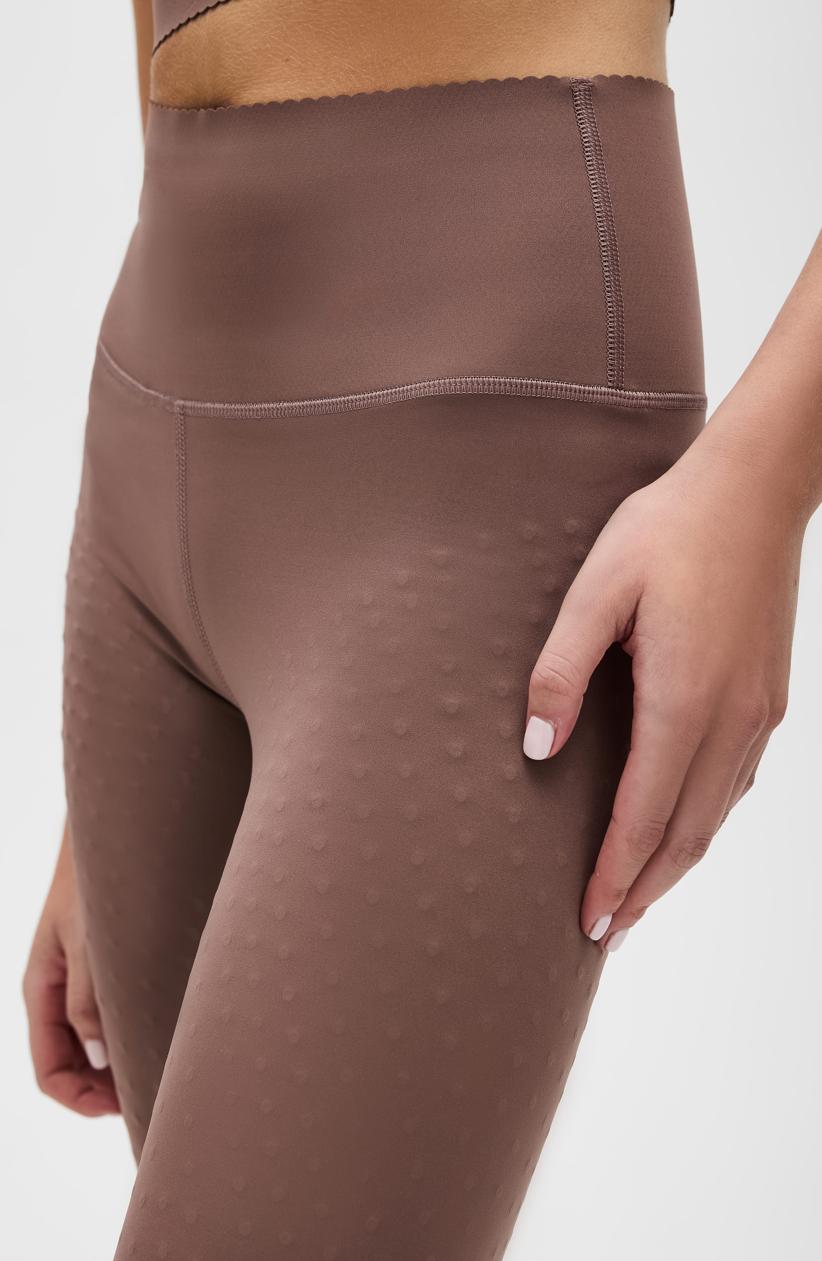 Woman wearing brown Adorn high-waisted sculpting leggings with scalloped hem detail