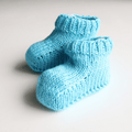Close up of soft blue and white knitted baby booties from the Cotton Candy Knitting Kit
