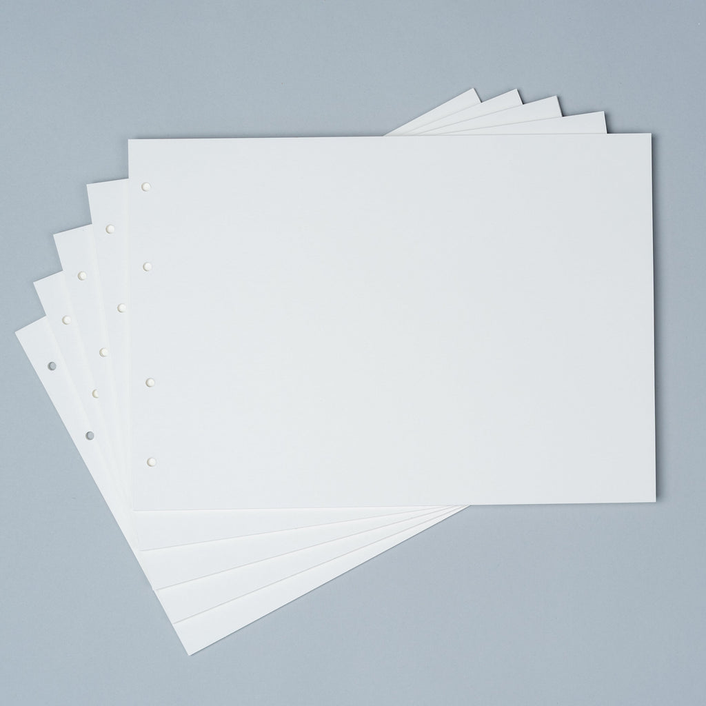 Stack of premium loose leaf photo album refill paper in Creamy White, Craft, and Black