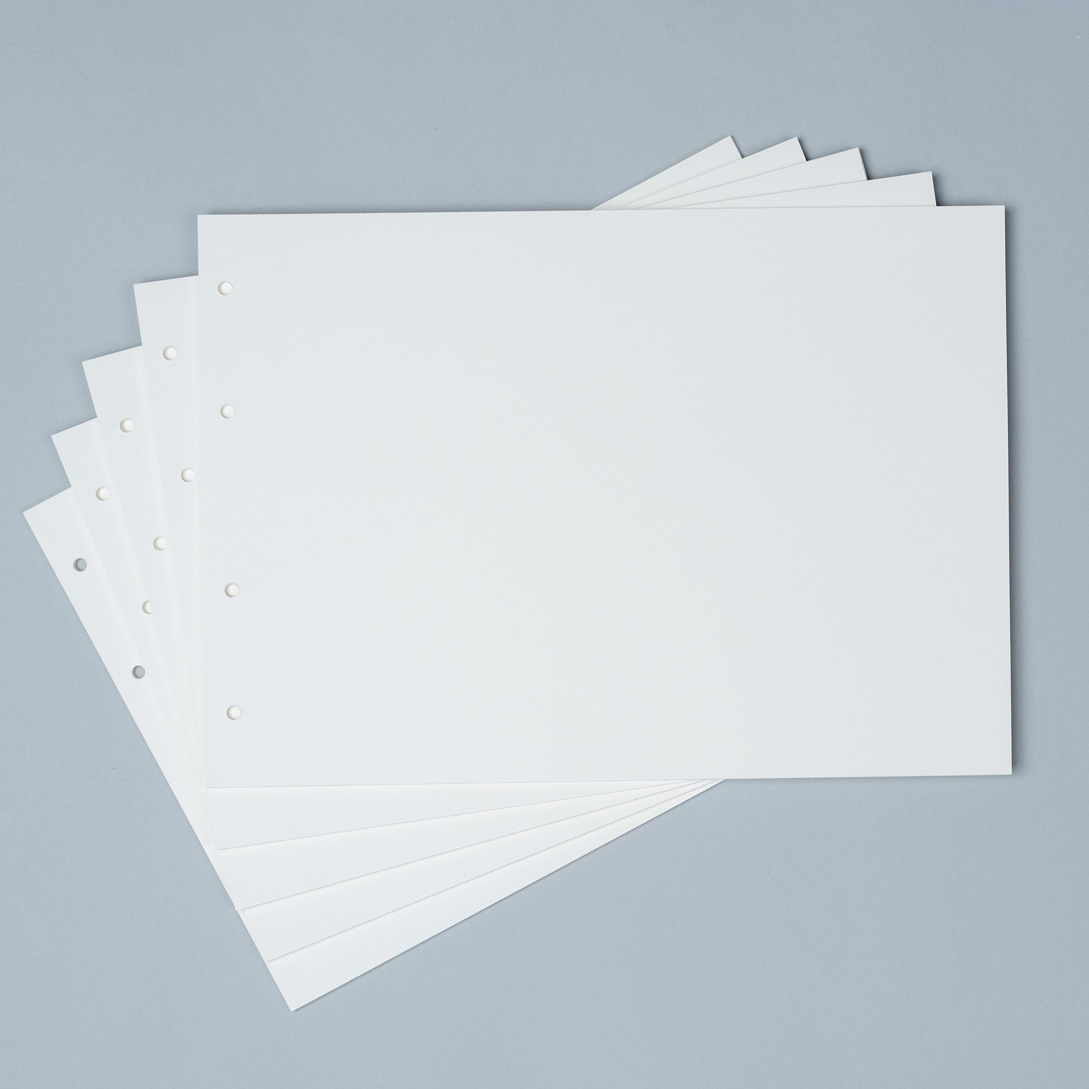 Stack of premium loose leaf photo album refill paper in Creamy White, Craft, and Black