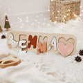 Personalized wooden name puzzle for girls featuring colorful letters on a natural wood board.