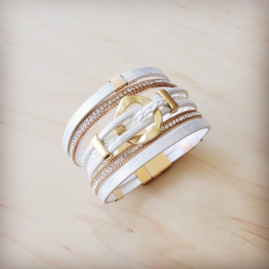 White and gold multi-strand magnetic cuff bracelet with braided leather-look strips and crystal details.