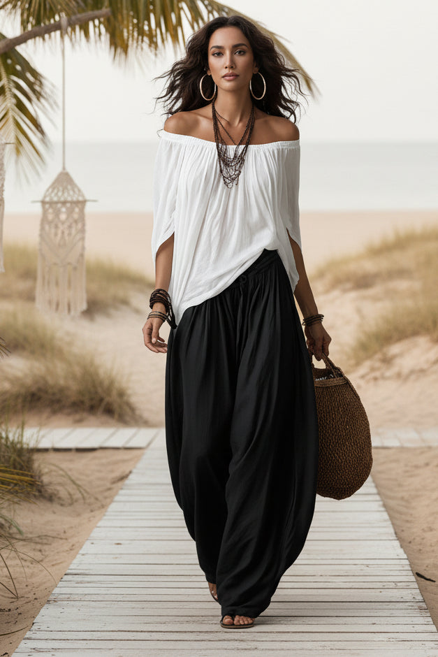 Woman wearing a stylish one-shoulder cotton top and wide-leg trousers, relaxed-chic bohemian loungewear set.