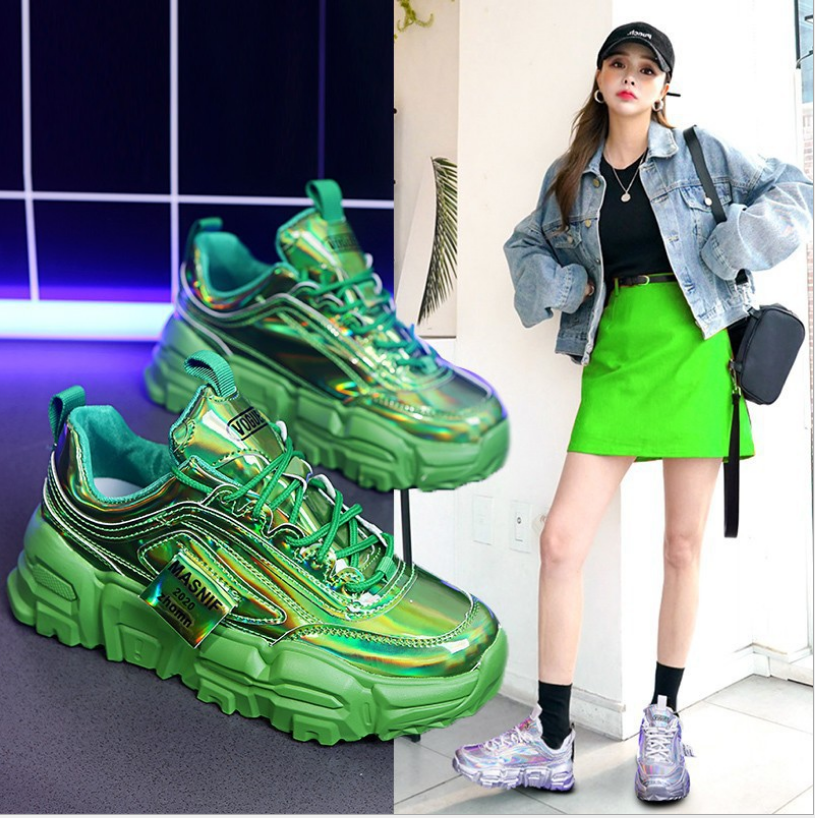 A pair of Women's Dazzle Green chunky dad sneakers with an iridescent metallic finish and a thick green sole, shown both individually and worn by a model in a vibrant outfit.