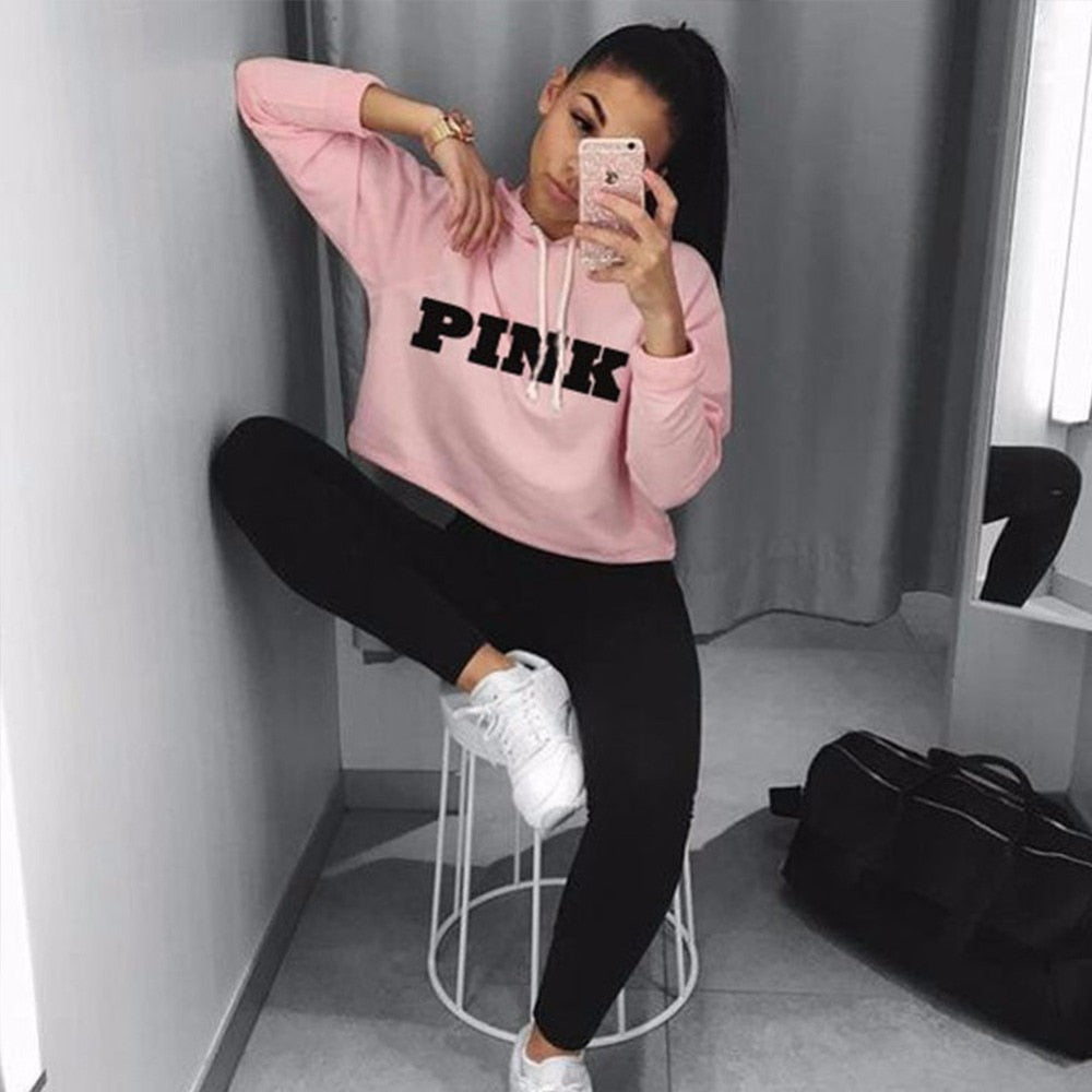 Model wearing a vibrant pink cropped oversized hoodie in Harajuku style, showcasing its relaxed fit and contemporary design.