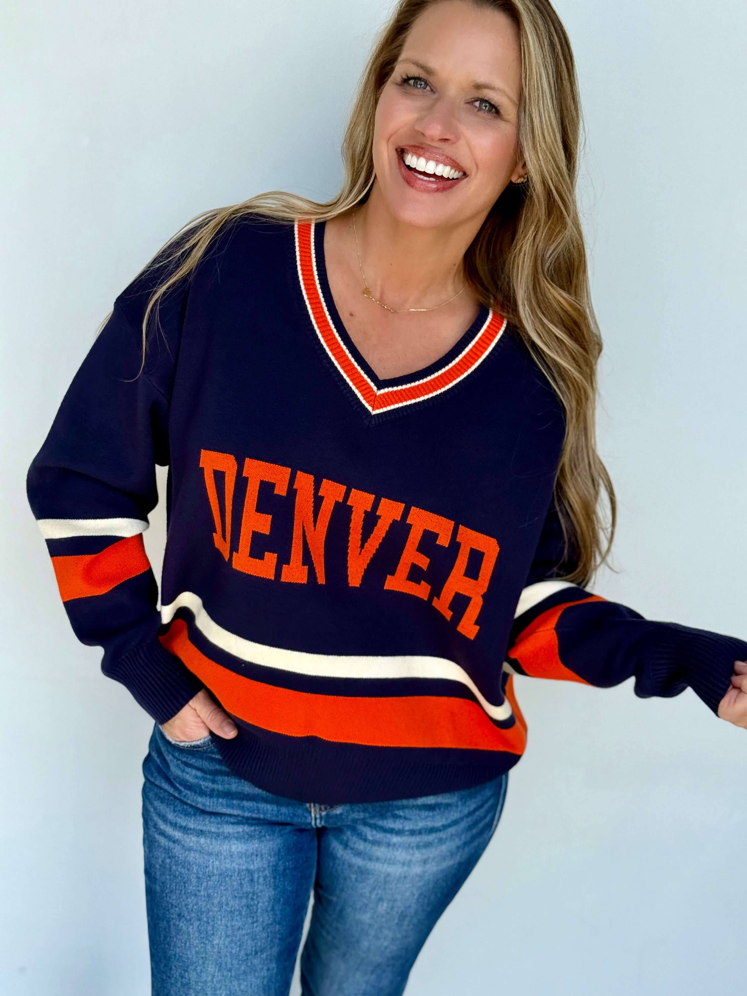 Denver University varsity style knit sweater in navy, orange, and cream colors.