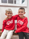 Child wearing a black Jesus Varsity Crew sweatshirt with clean white lettering.