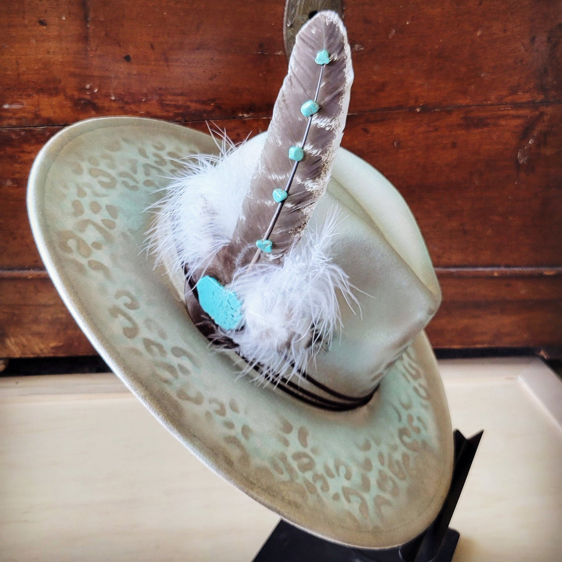 Hand-painted mint color cowgirl hat with leopard print pattern and a boho feather and turquoise stone hat band.