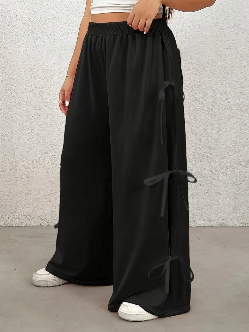 Model wearing wide leg elastic waist pants with bow detail in a playful Harajuku street style, showing the full length and comfortable fit.