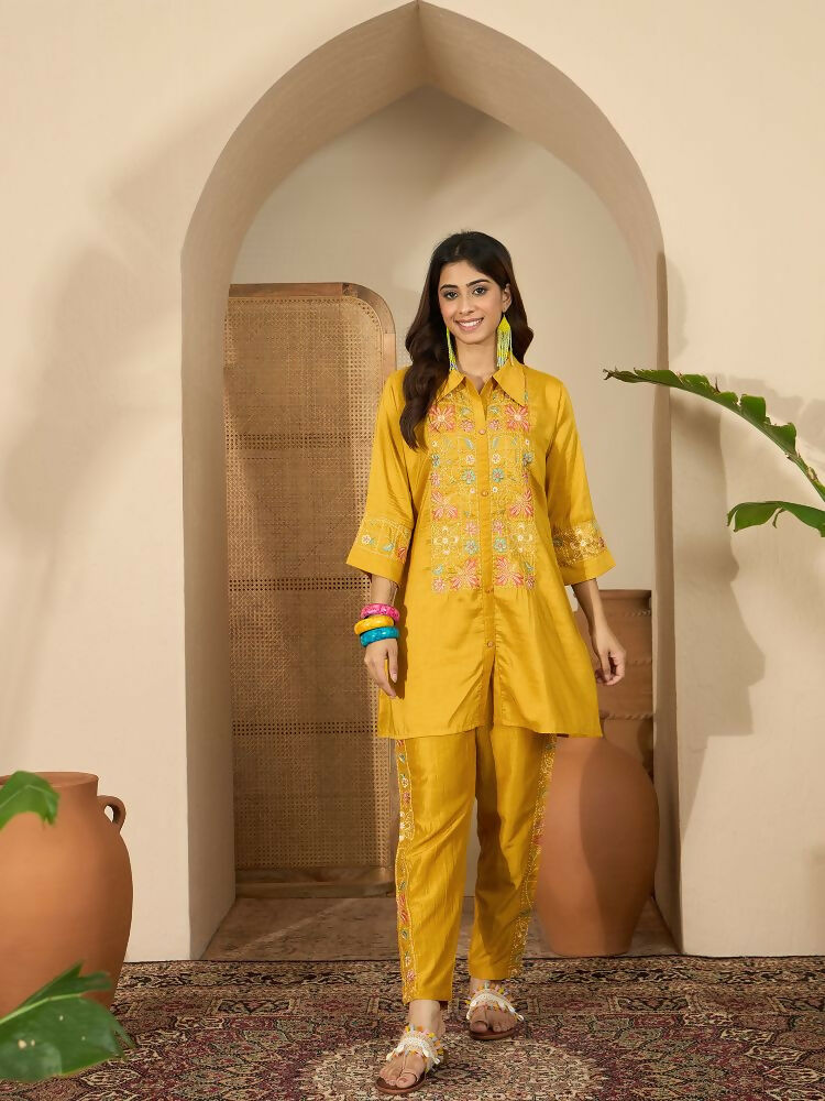 Woman wearing a mustard Roman Silk embroidered kurta set with a shirt collar