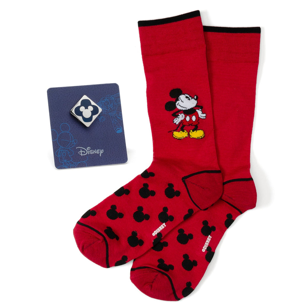 A pair of red socks with a black Mickey Mouse pattern and a blue enamel Mickey Mouse lapel pin on a display card.