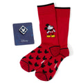 A pair of red socks with a black Mickey Mouse pattern and a blue enamel Mickey Mouse lapel pin on a display card.