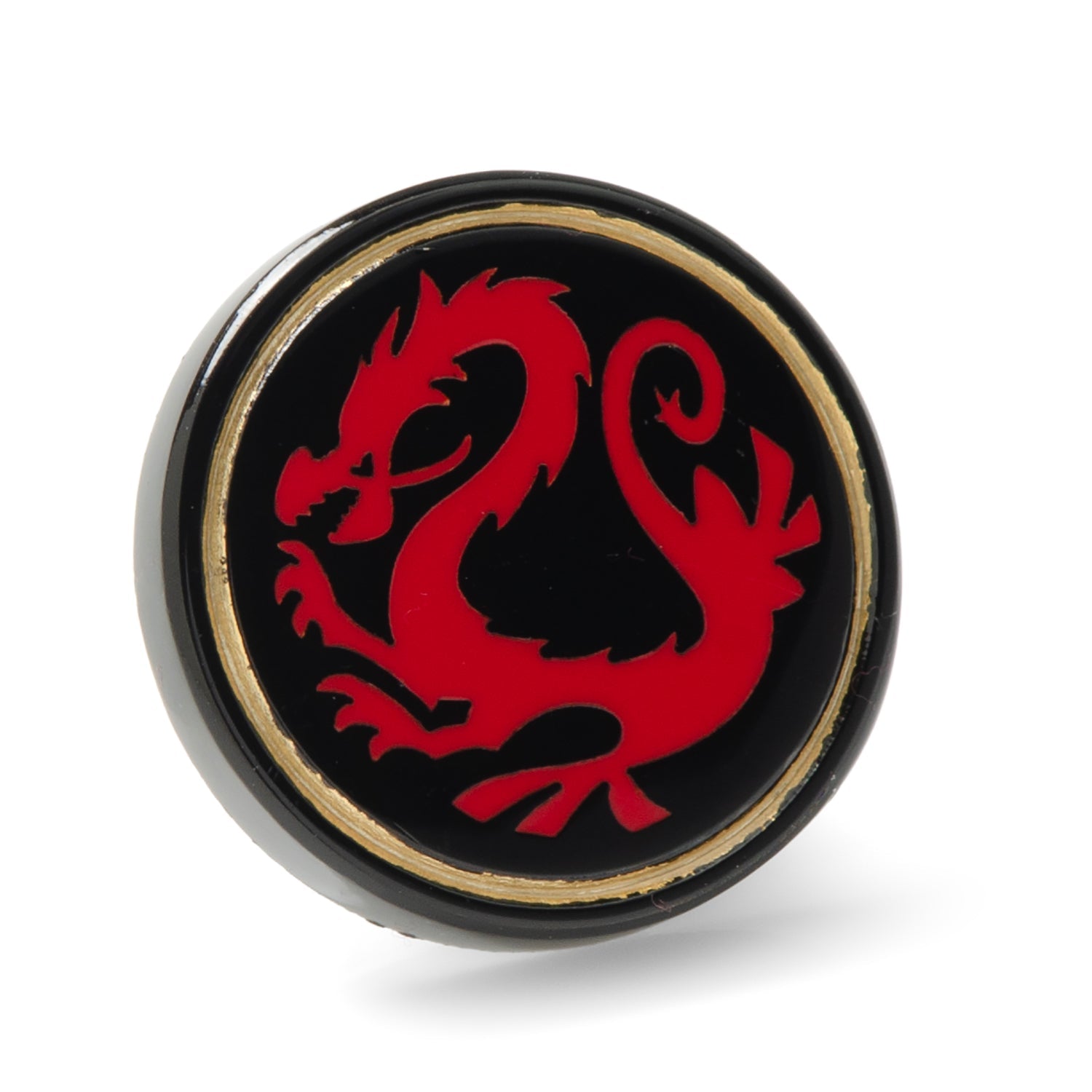 A close-up of a circular Disney Mulan Mushu lapel pin featuring a red dragon on a black base with gold trim.