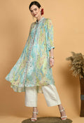 A woman wearing a mint-green midi kurta set with a geometric print, collared neckline, and three-quarter sleeves.