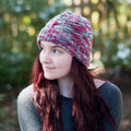 Unisex Ash Cave cable knit beanie in Merino wool with ombre detail, available in pink, teal, and grey.