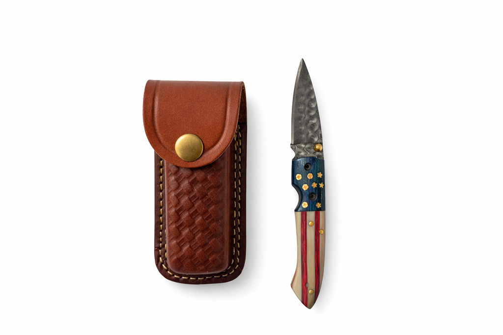 Titan Patriot Damascus folding knife with red, white, and blue handle and patterned steel blade.