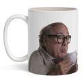 A high-contrast ceramic coffee mug featuring a portrait of Danny DeVito against a neutral background.