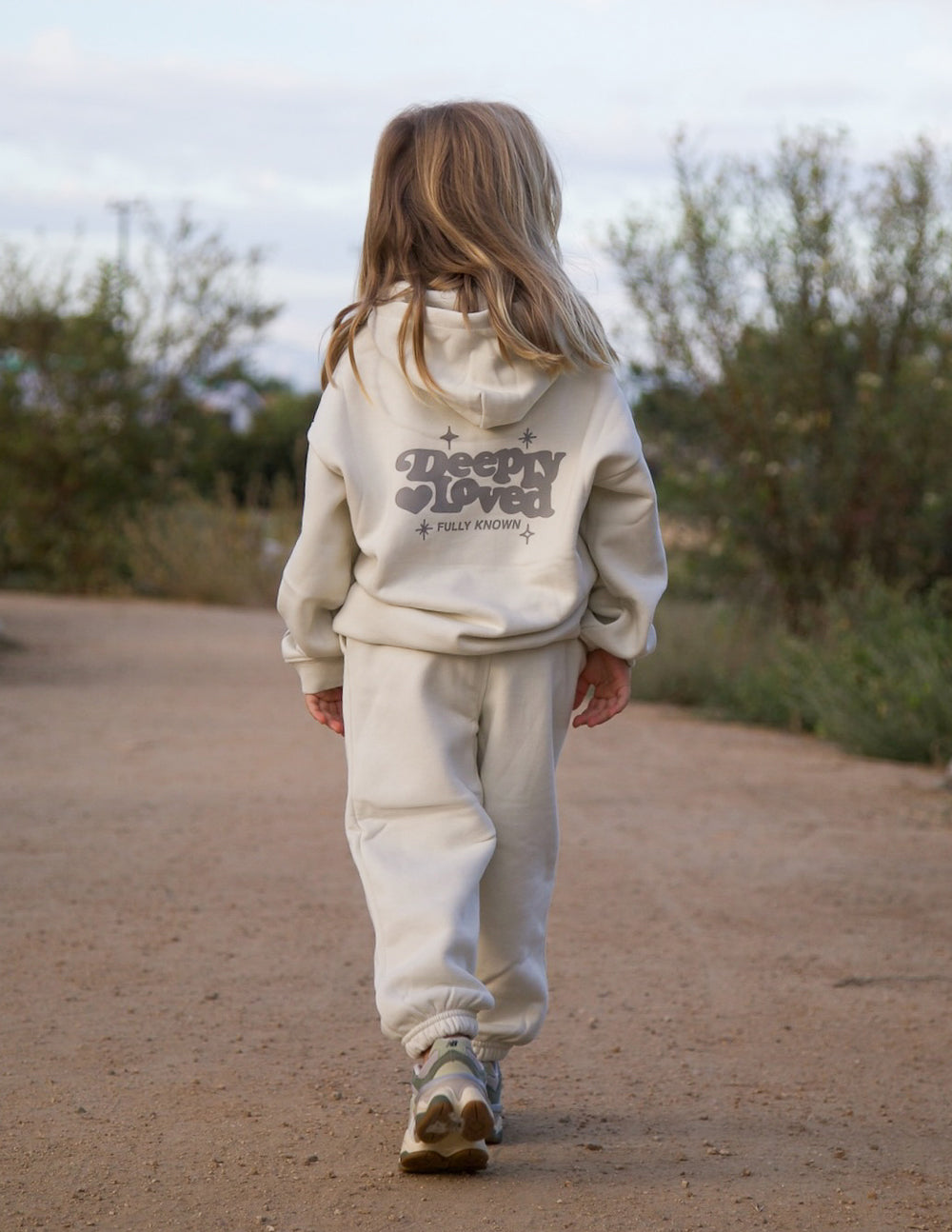 Child wearing an oversized, cozy Deeply Loved hoodie, perfect for layering and comfort.