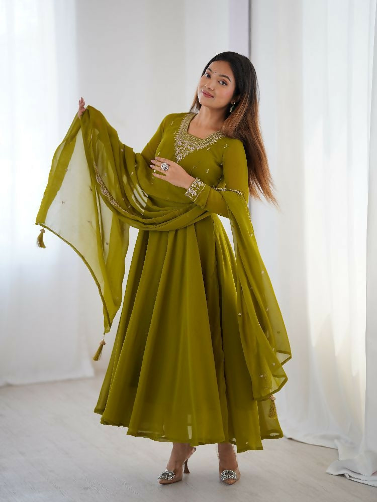 Woman wearing a monochromatic olive green midi kurta set with sequence embroidery and long sleeves.