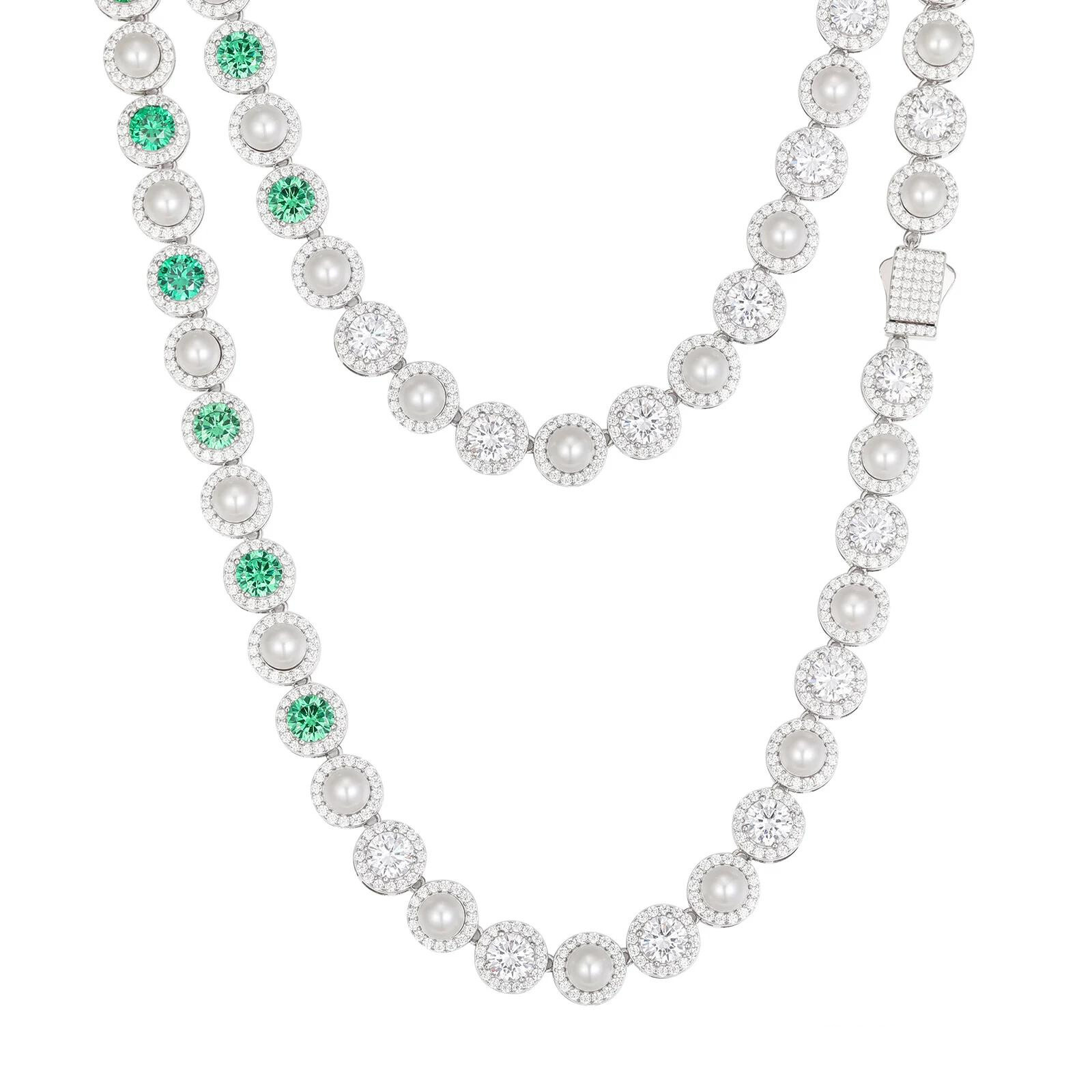 Sterling silver necklace with alternating white pearls and round green gemstones, featuring sparkling clear stone halos, worn by a model and shown on a white background.