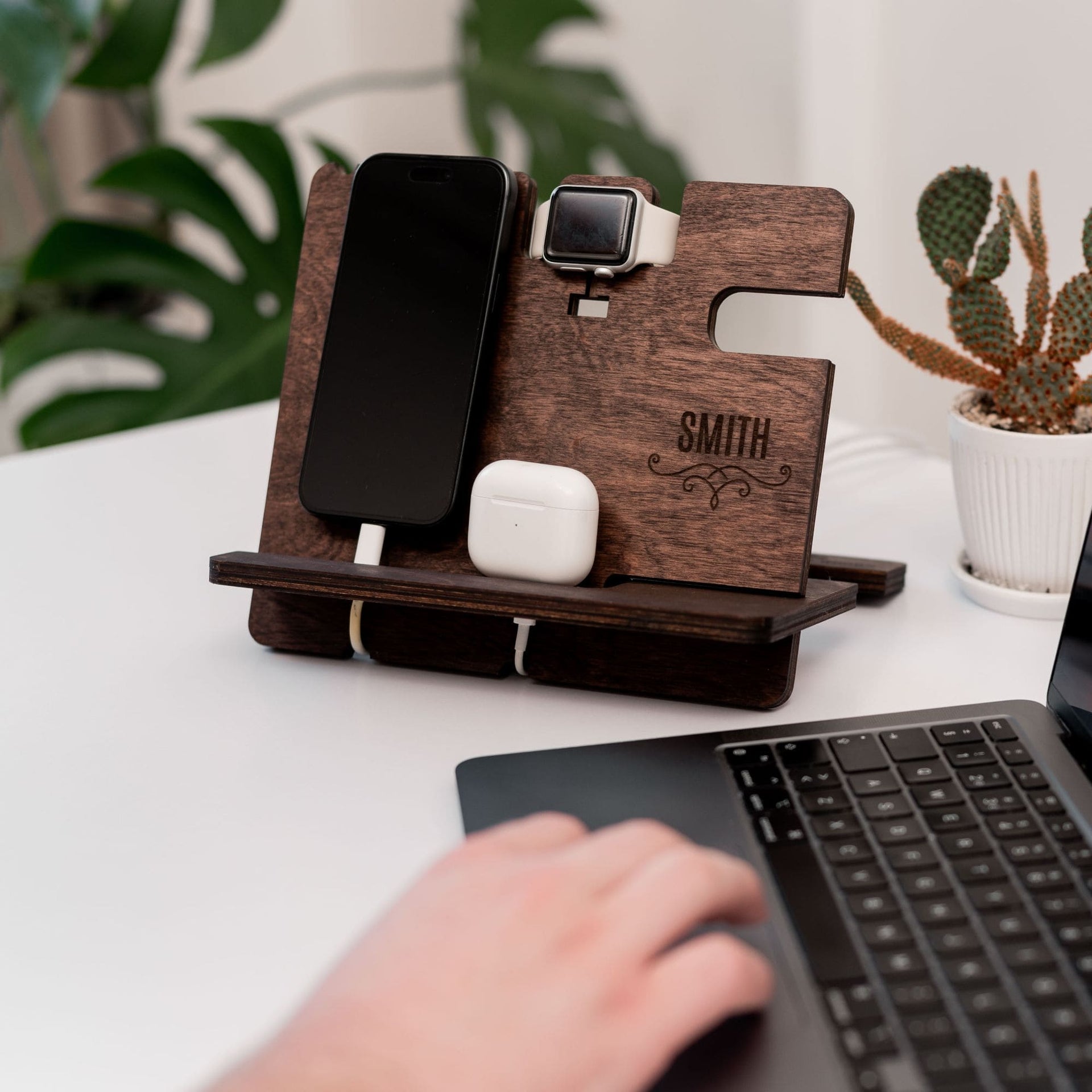 Handcrafted dark walnut wooden docking station organizing a phone, keys, wallet, and watch on a desk