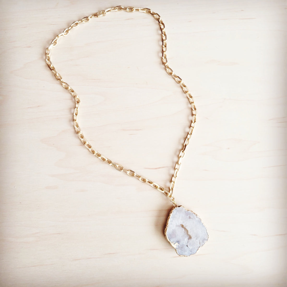 Matte gold gilded agate pendant necklace on a gold-tone oval link chain