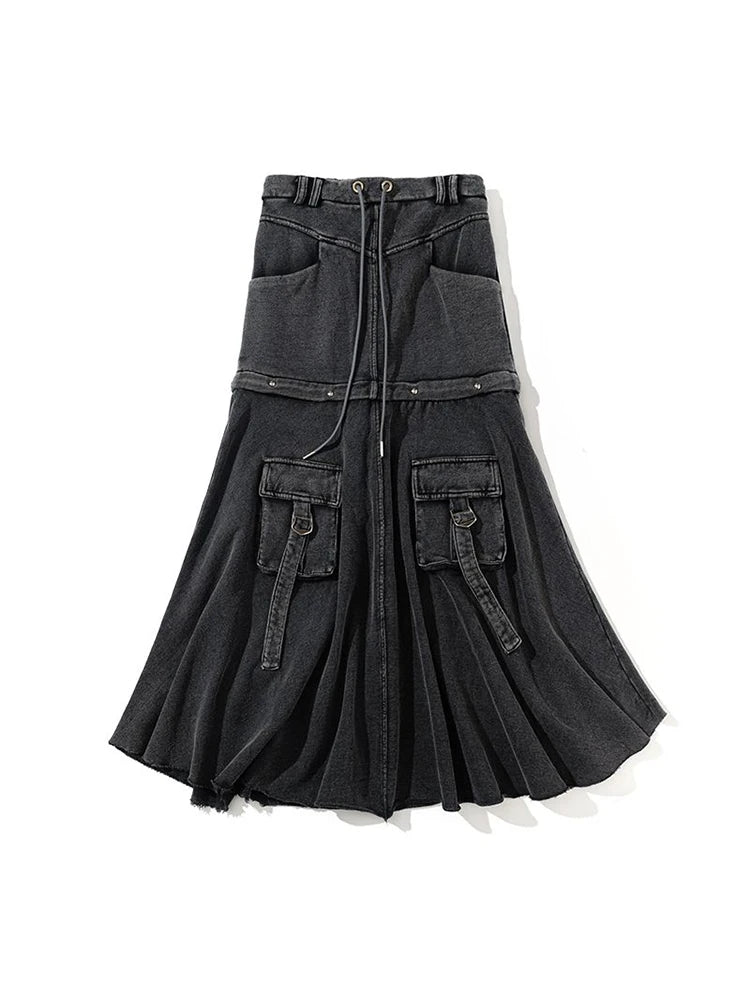 Model wearing Y2K black distressed denim midi skirt with cargo pockets and drawstring waist, styled for a street-style look.