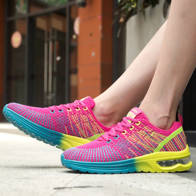 Women's Harajuku style pink, teal, and yellow air cushion sneakers worn on feet, viewed from the side