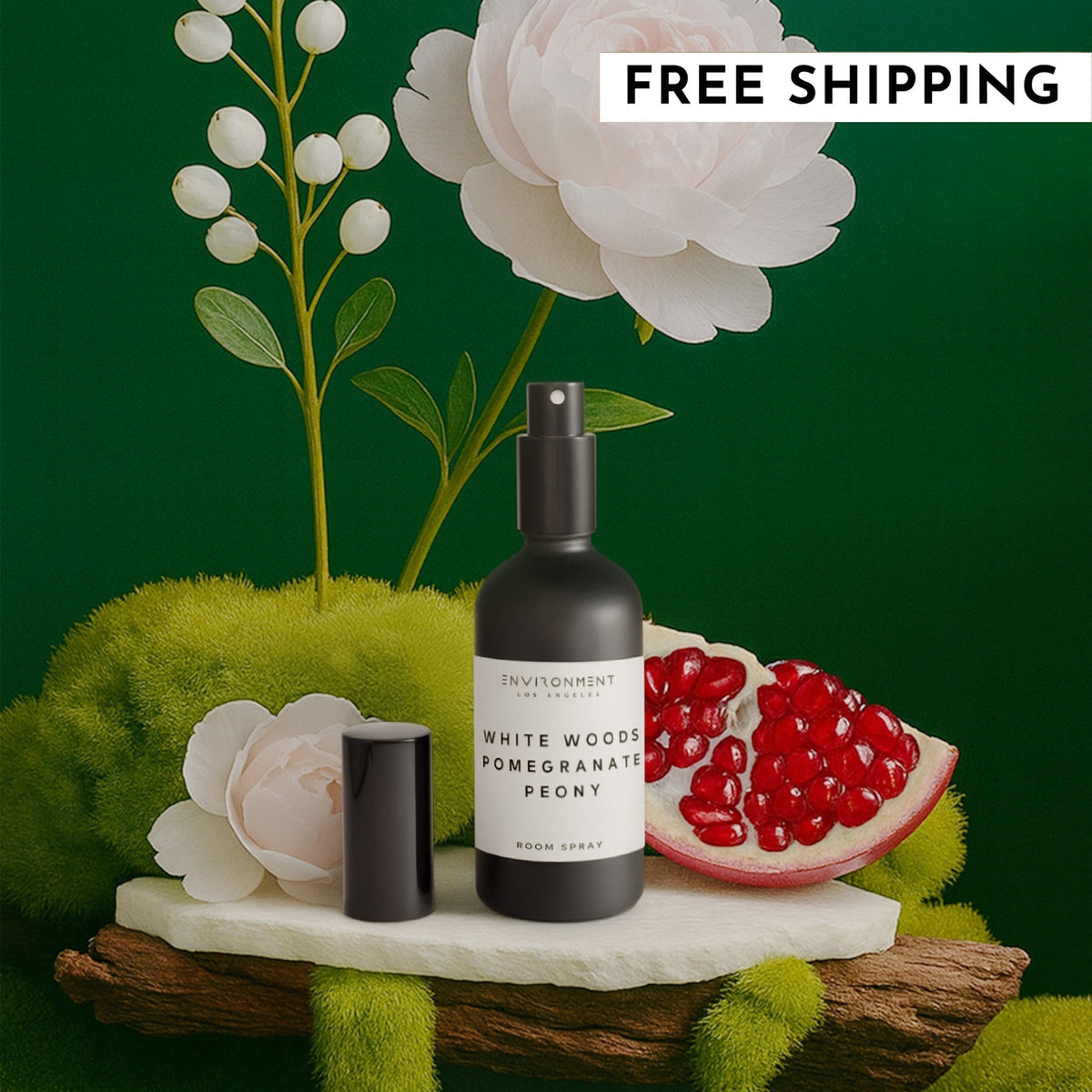 White Woods Pomegranate Peony room spray bottle styled with fresh pomegranate and peony flowers