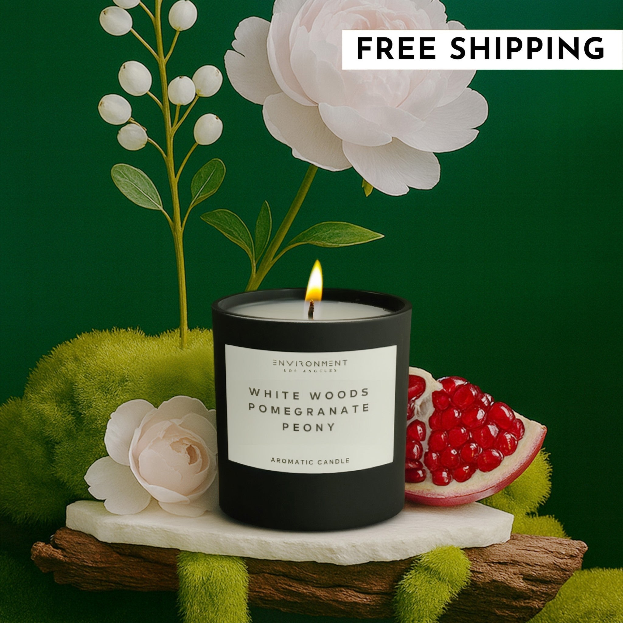 8oz Black jar candle labeled White Woods Pomegranate Peony displayed with pomegranate and peony flower