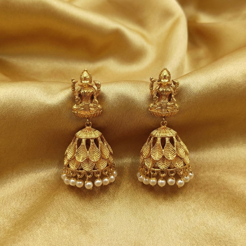 Close up of gold Goddess Laxmi temple jhumka earrings with ruby leaf details