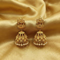 Close up of gold Goddess Laxmi temple jhumka earrings with ruby leaf details