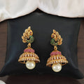 Matte gold peacock design Jhumka earrings with traditional kemp stones