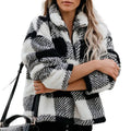 A woman wearing a thick, black and white plaid sherpa-style zip-up jacket with a stand collar.