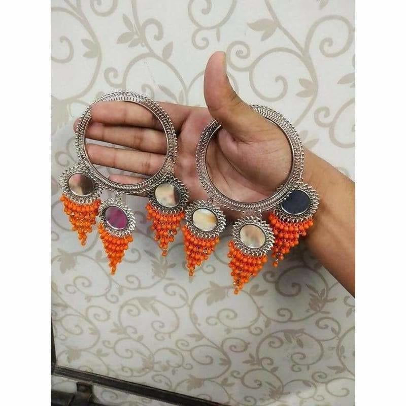 Orange pearl and mirror work bangles with decorative hanging latkans