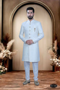 A young boy wearing a crisp white Indo-Western kurta set with self-design fabric and matching polo pyjamas.