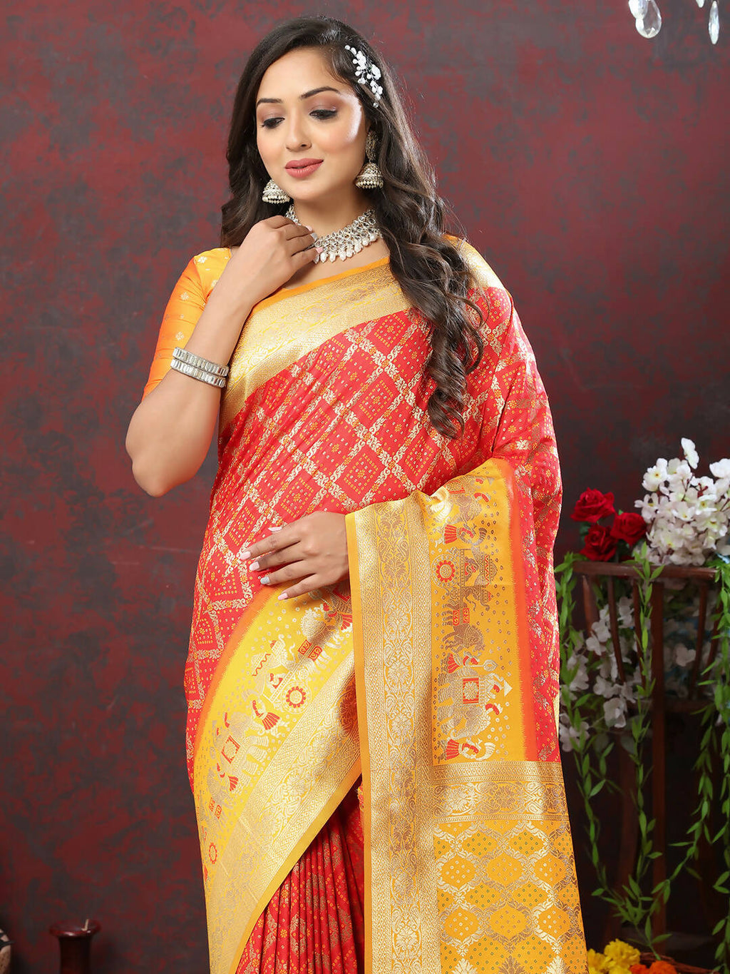Red and Yellow Patola silk saree with Meenakari weaving design displayed beautifully.