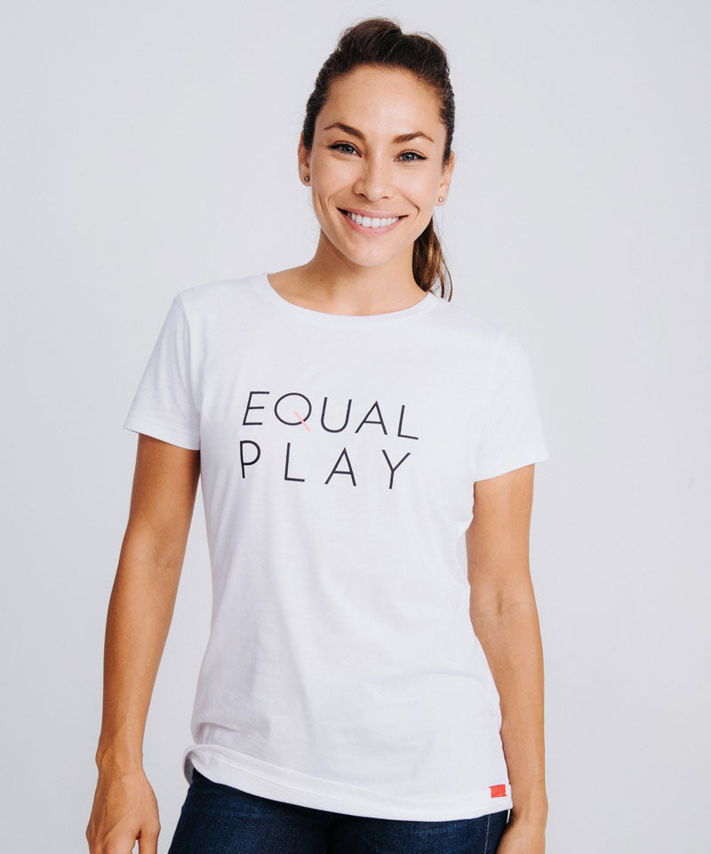 A smiling woman wearing a white short-sleeved crew neck t-shirt with the text Equal Play on the front.