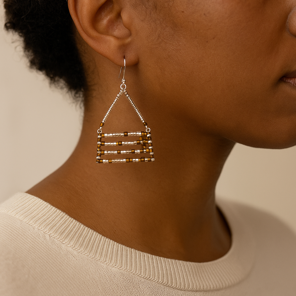 Artisan-made Zelalem geometric drop earrings in polished silver and amber-gold finishes.