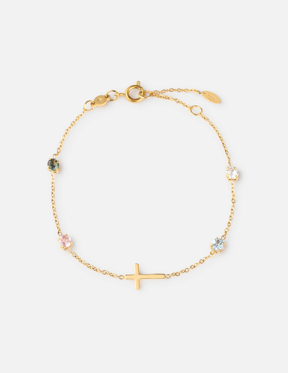 Close up of gold-plated cable chain bracelet with multi-color round crystal bezel accents on a woman's wrist