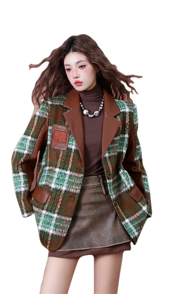 Model wearing a green plaid wool blend blazer jacket with brown faux leather lapels and sleeves, paired with a brown turtleneck and a brown mini skirt, creating a stylish autumn outfit.