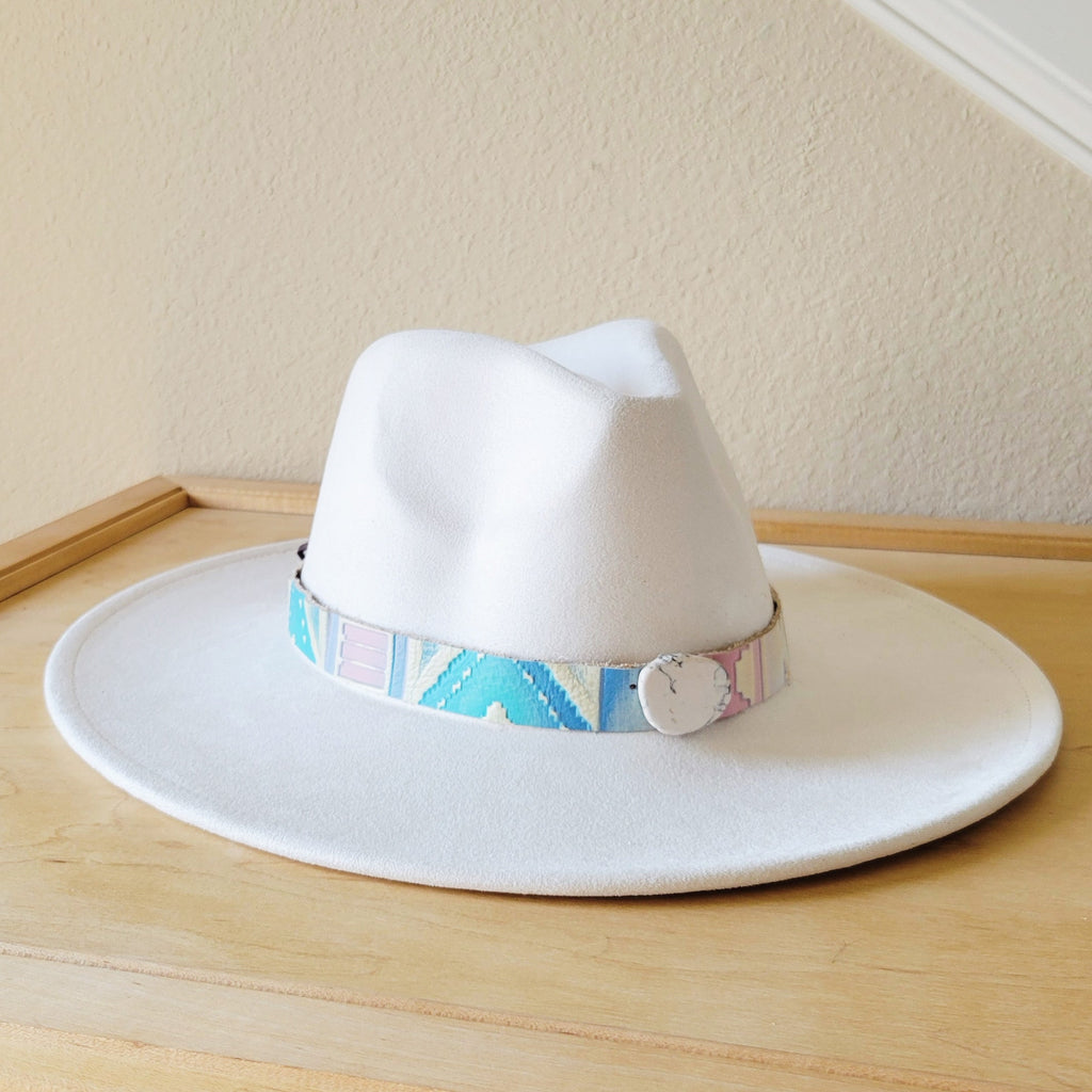 Pastel colored Navajo embossed leather hat band with a large round white stone accent on a white hat